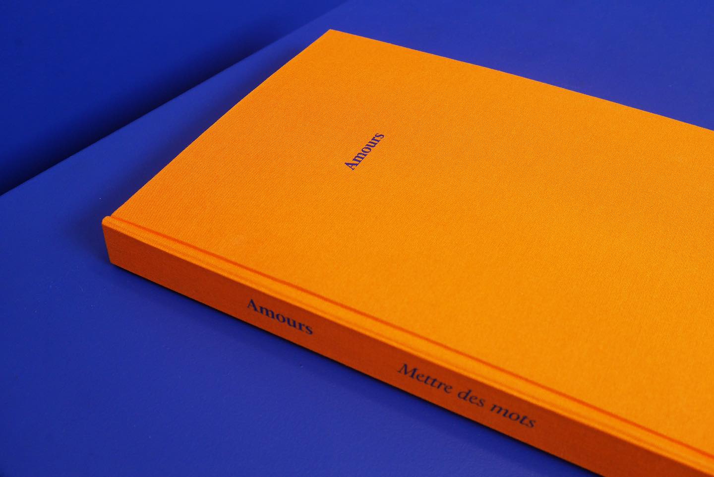 Livre relié à couverture orange sur fond bleu